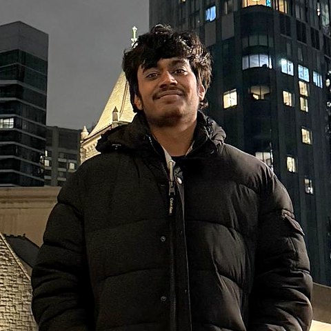 Suyash Maniyar at night in front of city buildings
